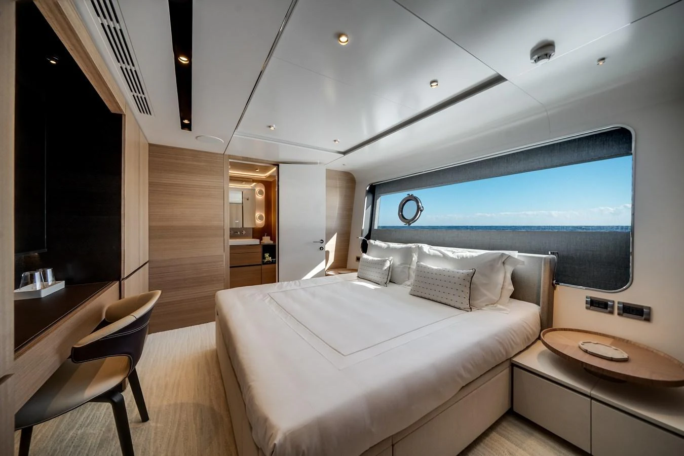 A luxurious stateroom with a large bed and a scenic ocean view through the window. aboard OCEAN ALEXANDER 35P05 Yacht for Sale