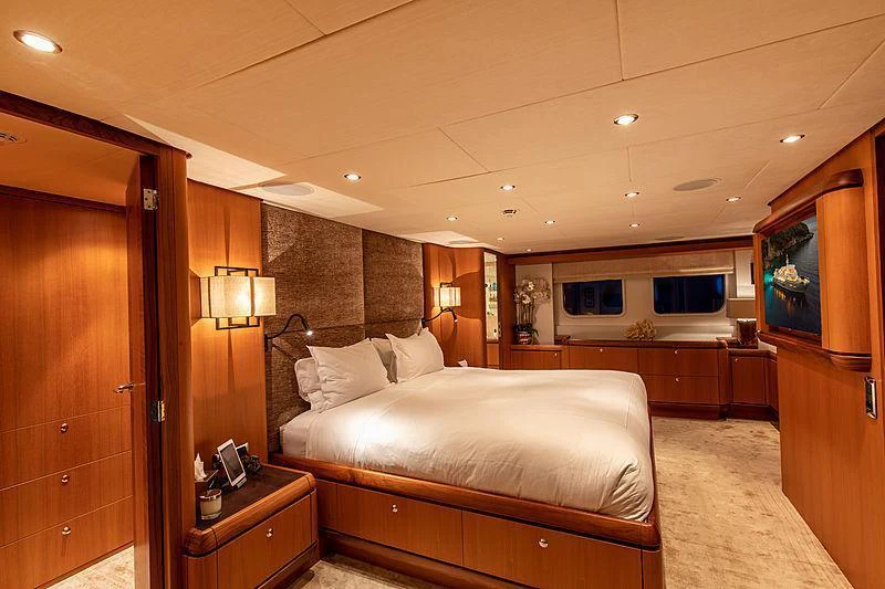 a bedroom with a bed and a wood cabinet aboard GALENA Yacht for Charter