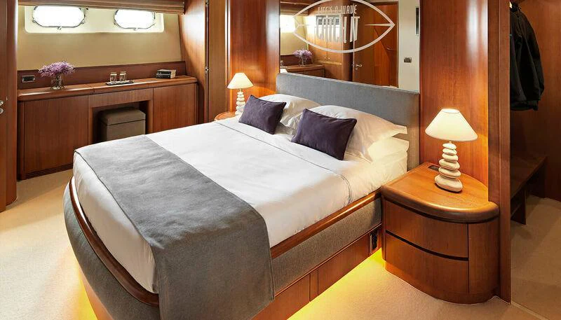 a bed with a white sheet aboard MARTINA Yacht for Charter