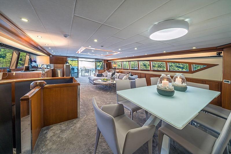 a room with a table chairs and a couch aboard SAN LIMI Yacht for Charter