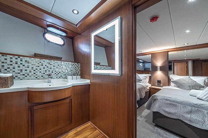 a bedroom with a bed and a sink aboard SAN LIMI Yacht for Charter