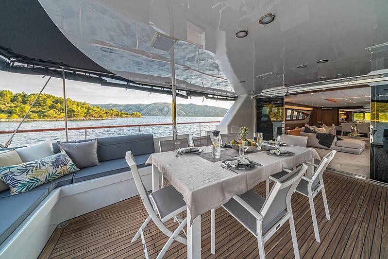 a table and chairs on a deck aboard SAN LIMI Yacht for Charter