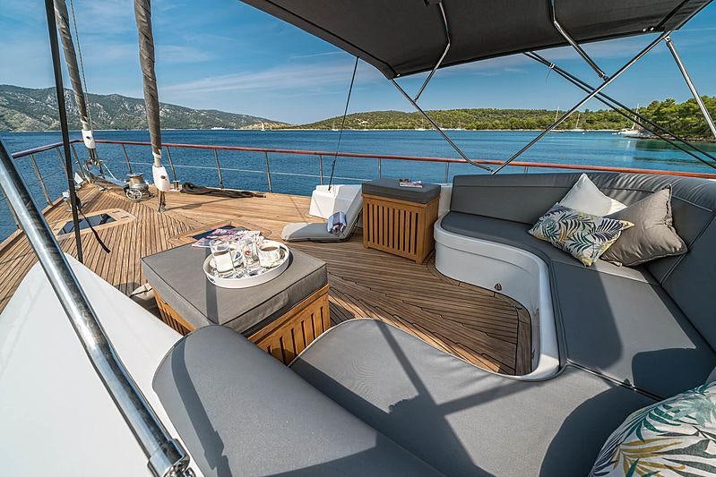 a deck with a view of the ocean and the land below aboard SAN LIMI Yacht for Charter