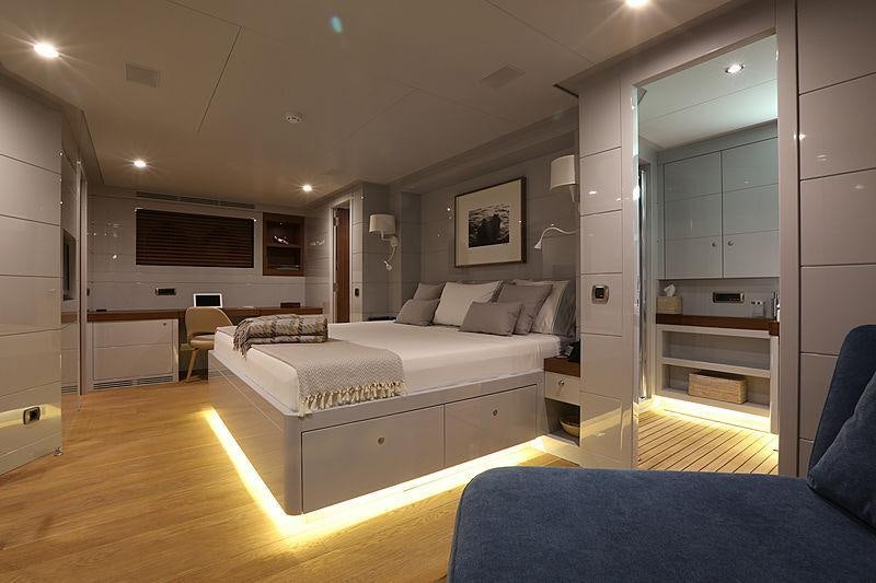 a bedroom with a bed and a desk aboard ONLY NOW Yacht for Charter