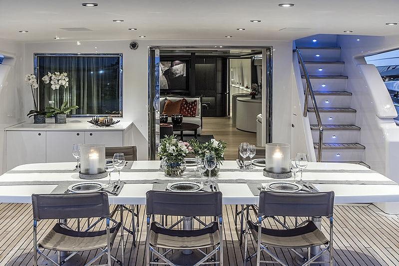 a large white table with chairs and a large window aboard PROJECT STEEL Yacht for Charter