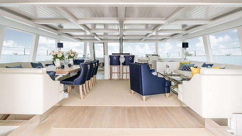 a room with a table chairs and a couch aboard BUNDALONG Yacht for Charter