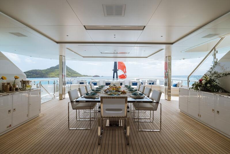 a large white kitchen with a large table and chairs aboard RESILIENCE Yacht for Charter