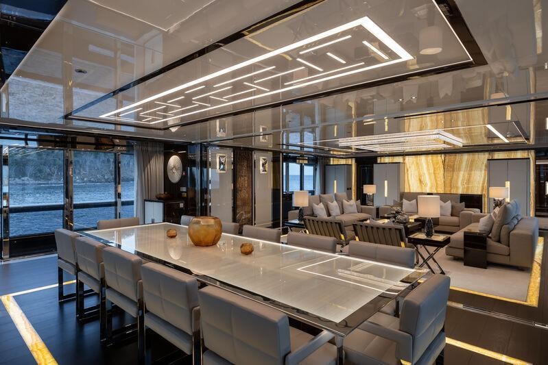 a large room with a large table and chairs aboard RESILIENCE Yacht for Charter