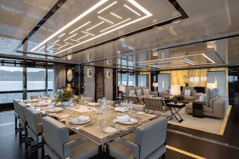 a large room with a table and chairs aboard RESILIENCE Yacht for Charter