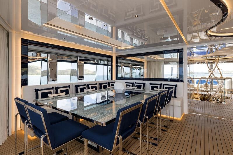 a large room with a table and chairs aboard RESILIENCE Yacht for Charter