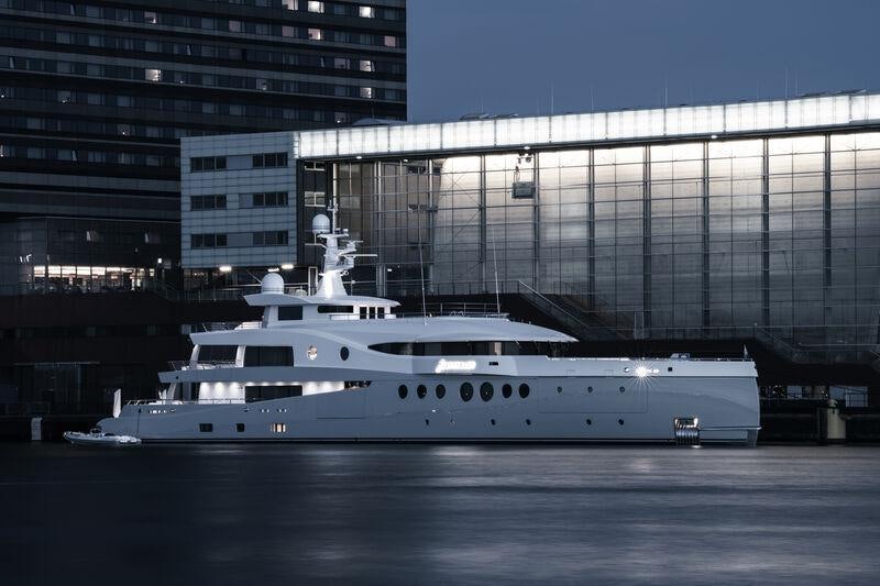 a white boat in a body of water next to a building aboard STARDUST Yacht for Sale
