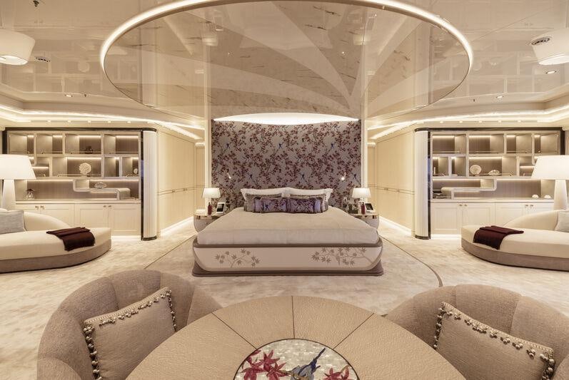 a large living room with a large white couch and a large mirror aboard AHPO Yacht for Charter