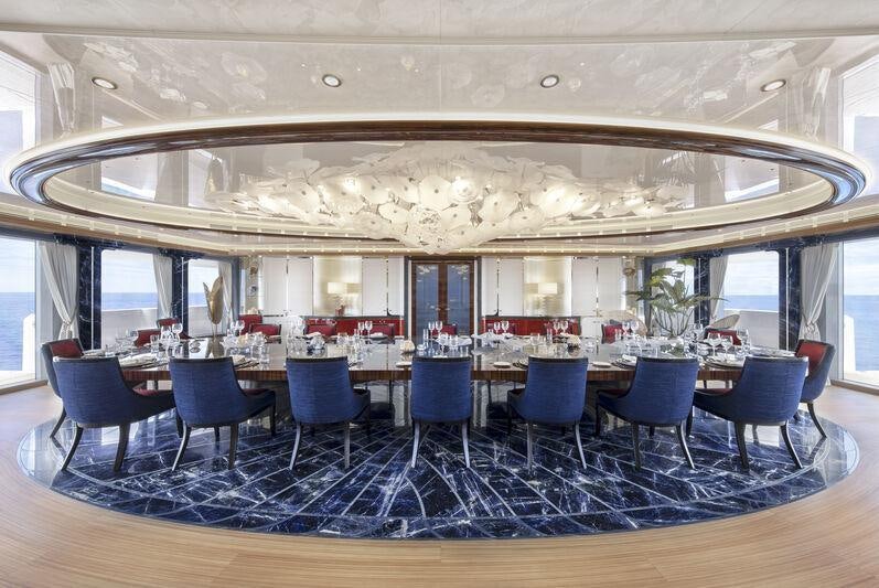 a large room with tables and chairs aboard AHPO Yacht for Charter