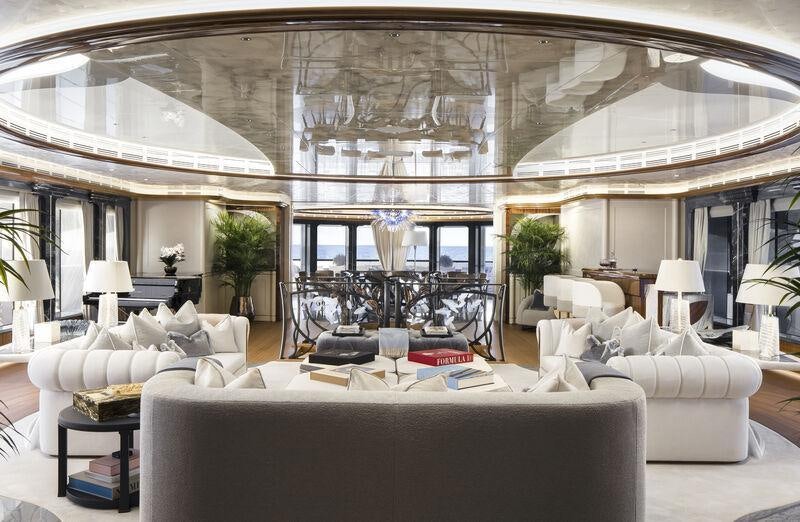a large living room with a large chandelier aboard AHPO Yacht for Charter