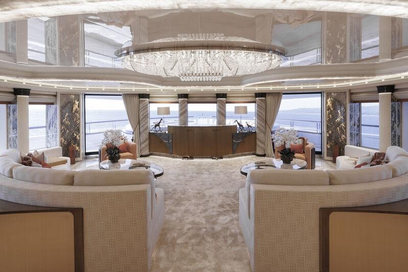 a large room with white furniture aboard AHPO Yacht for Charter