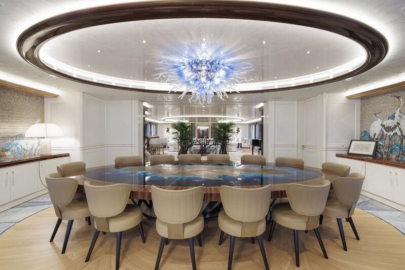 a large room with a large blue table and chairs aboard AHPO Yacht for Charter