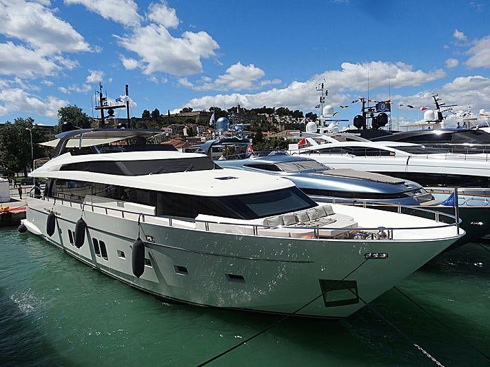 a large white boat sits in a harbor aboard DINAIA Yacht for Charter
