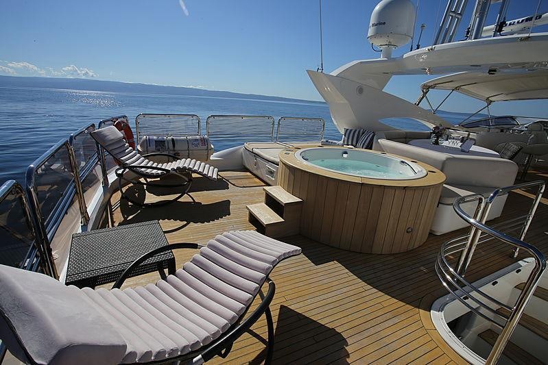 a deck with a table and chairs on it aboard BABY I Yacht for Charter