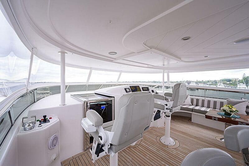 a room with a large white chair and a table with chairs aboard UNWINED Yacht for Charter