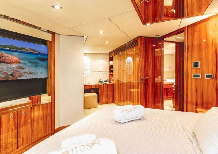a hotel room with a bed and a tv on the wall aboard SEA BREEZE ONE Yacht for Charter