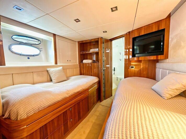 a room with a bed and a television aboard SEA BREEZE ONE Yacht for Charter