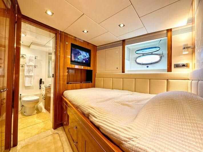 a bedroom with a bed and a television aboard SEA BREEZE ONE Yacht for Charter