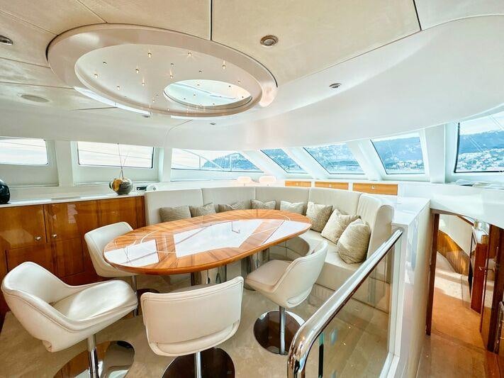 a room with a table chairs and a large window aboard SEA BREEZE ONE Yacht for Charter