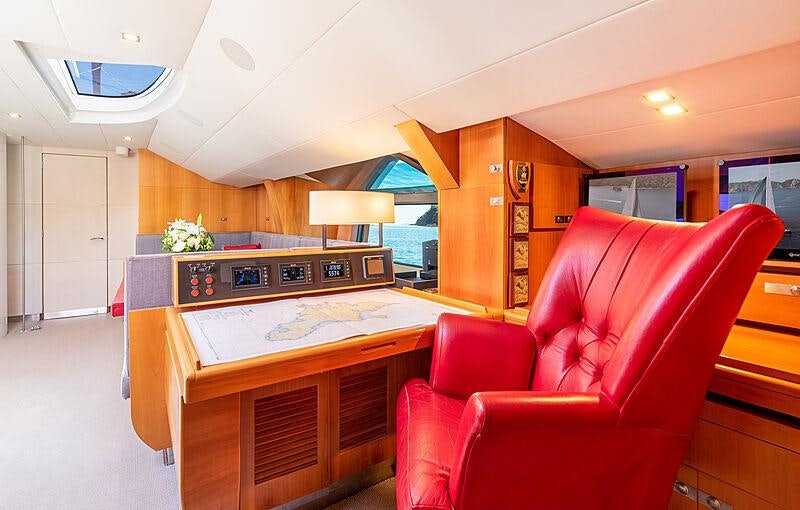 a room with a red couch and a desk with a computer on it aboard SILVERTIP Yacht for Charter