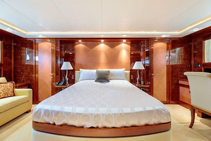 a bed with a white bed spread aboard OVAL Yacht for Charter