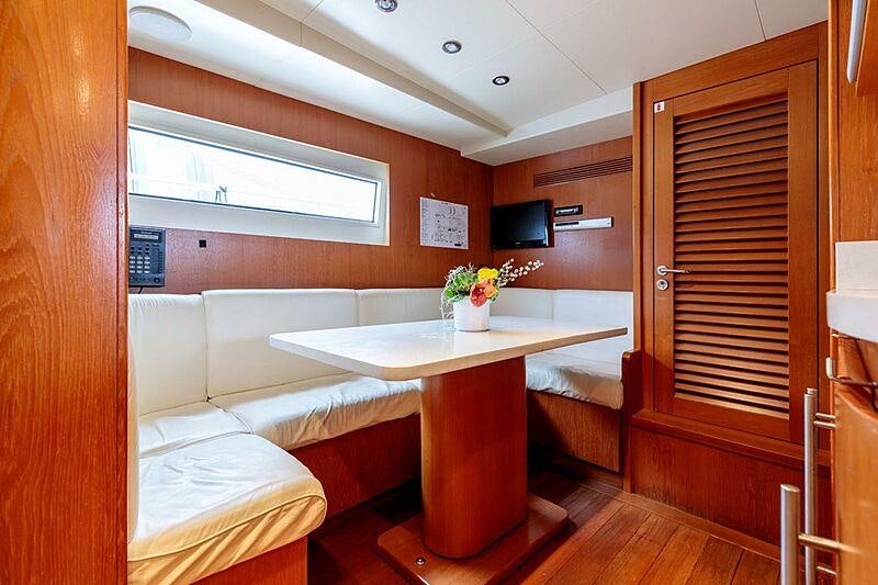 a room with a table and a couch aboard OVAL Yacht for Charter