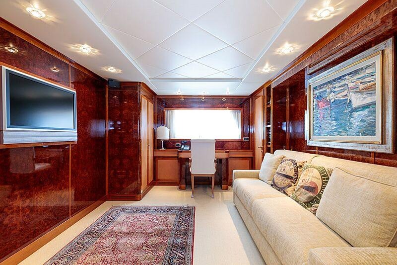 a room with a couch and a tv aboard OVAL Yacht for Charter