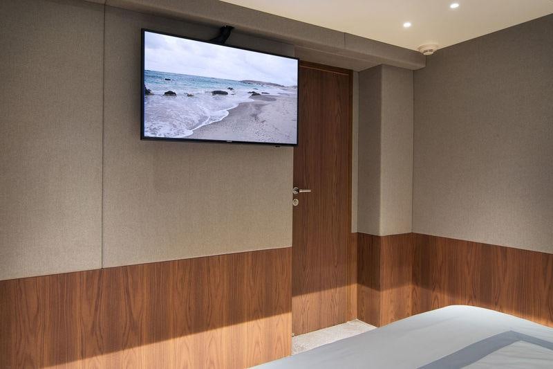 a room with a television and a wood wall aboard WHISPER V Yacht for Charter