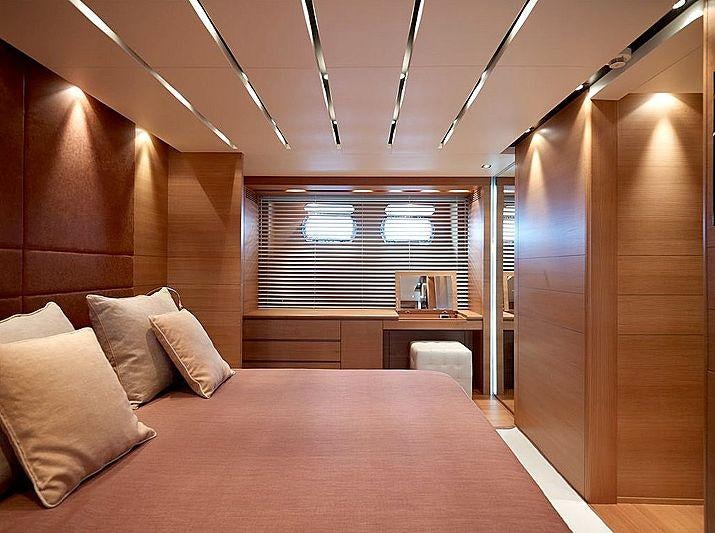 a bed with a pink bed spread aboard FELIGO V Yacht for Charter