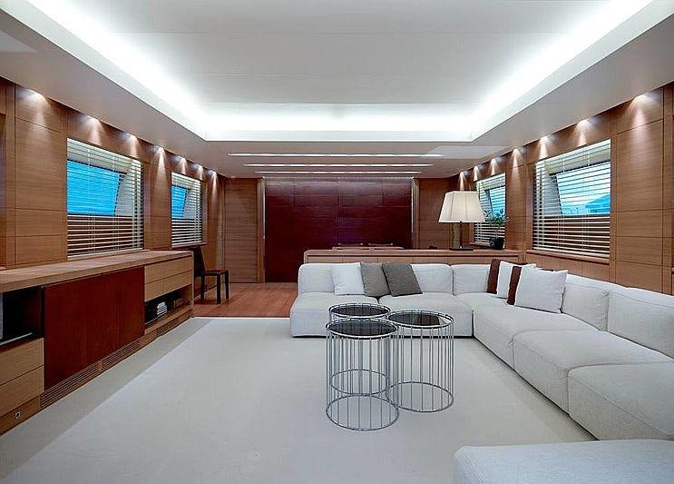 a large living room with a white couch and a red wall aboard FELIGO V Yacht for Charter