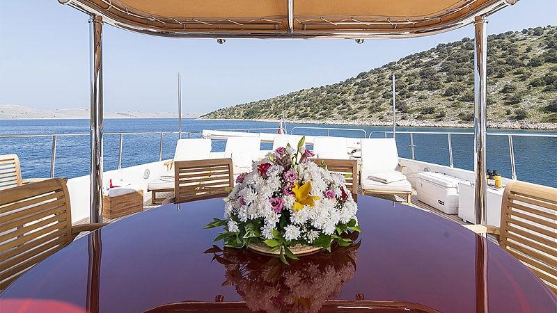 a table with flowers on it aboard IMAGINE Yacht for Charter