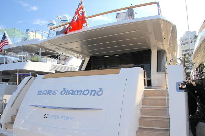 a boat with a flag on the deck aboard RARE DIAMOND Yacht for Charter
