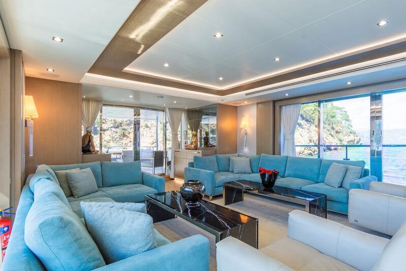 a living room with a blue couch and a coffee table aboard FREEDOM Yacht for Charter