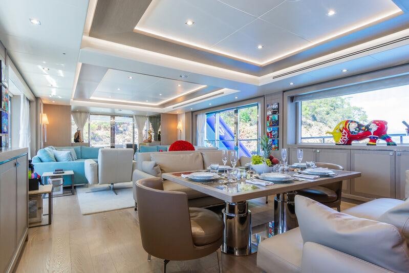 a large living room with a large table and chairs aboard FREEDOM Yacht for Charter