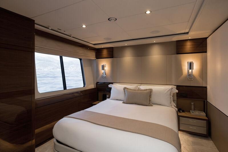 a bedroom with a bed and a window aboard RIVIERA LIVING Yacht for Charter