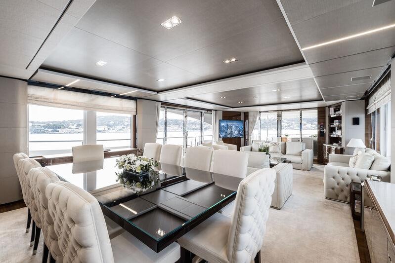 a large living room with a large table and chairs aboard RIVIERA LIVING Yacht for Charter