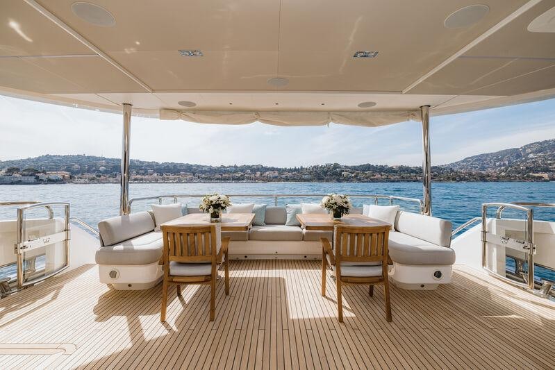 a room with a table chairs and a view of a city aboard RIVIERA LIVING Yacht for Charter