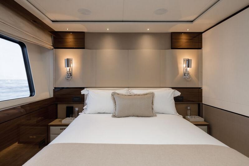 a bed with white sheets aboard RIVIERA LIVING Yacht for Charter