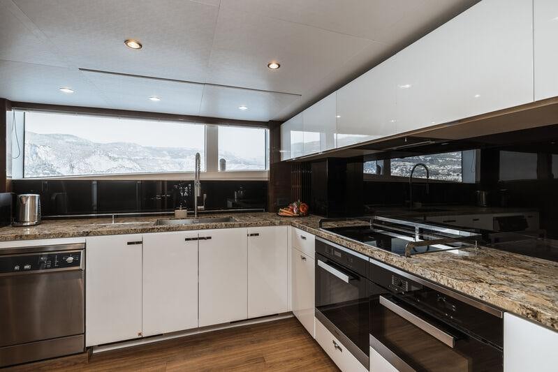 a kitchen with white cabinets aboard RIVIERA LIVING Yacht for Charter