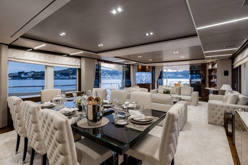 a room with tables and chairs aboard RIVIERA LIVING Yacht for Charter