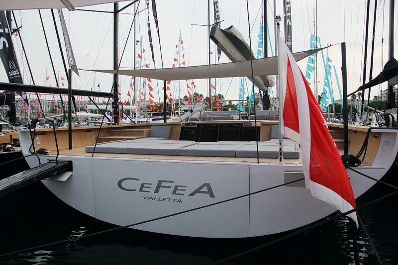 a white boat with red and black stripes on it aboard CEFEA Yacht for Charter