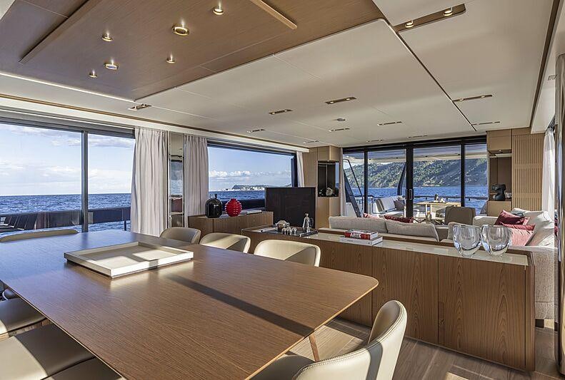 a large room with a large table and chairs aboard EPIC Yacht for Charter