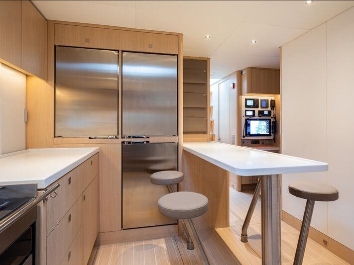 a kitchen with a fridge and a table aboard ALIX Yacht for Sale