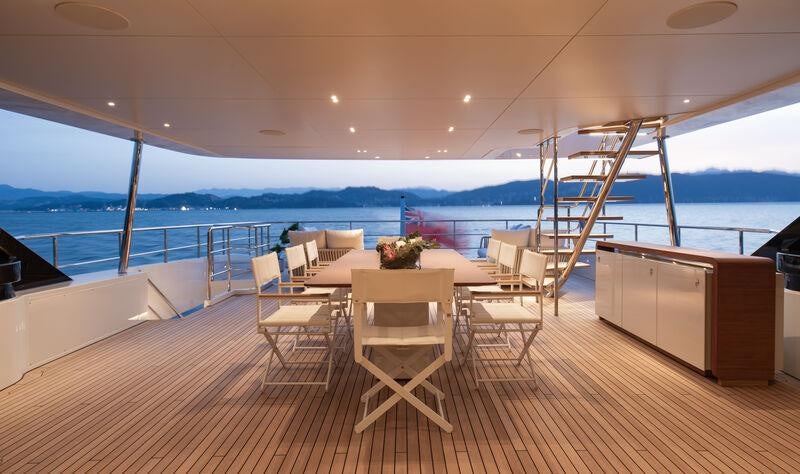 a room with a table and chairs on a deck aboard LEGEND Yacht for Charter