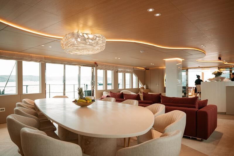 a large living room with a large table and chairs aboard REPOSADO Yacht for Charter
