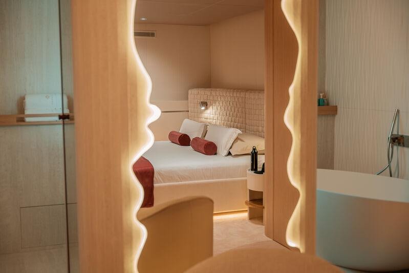 a room with a bed and a mirror aboard REPOSADO Yacht for Charter
